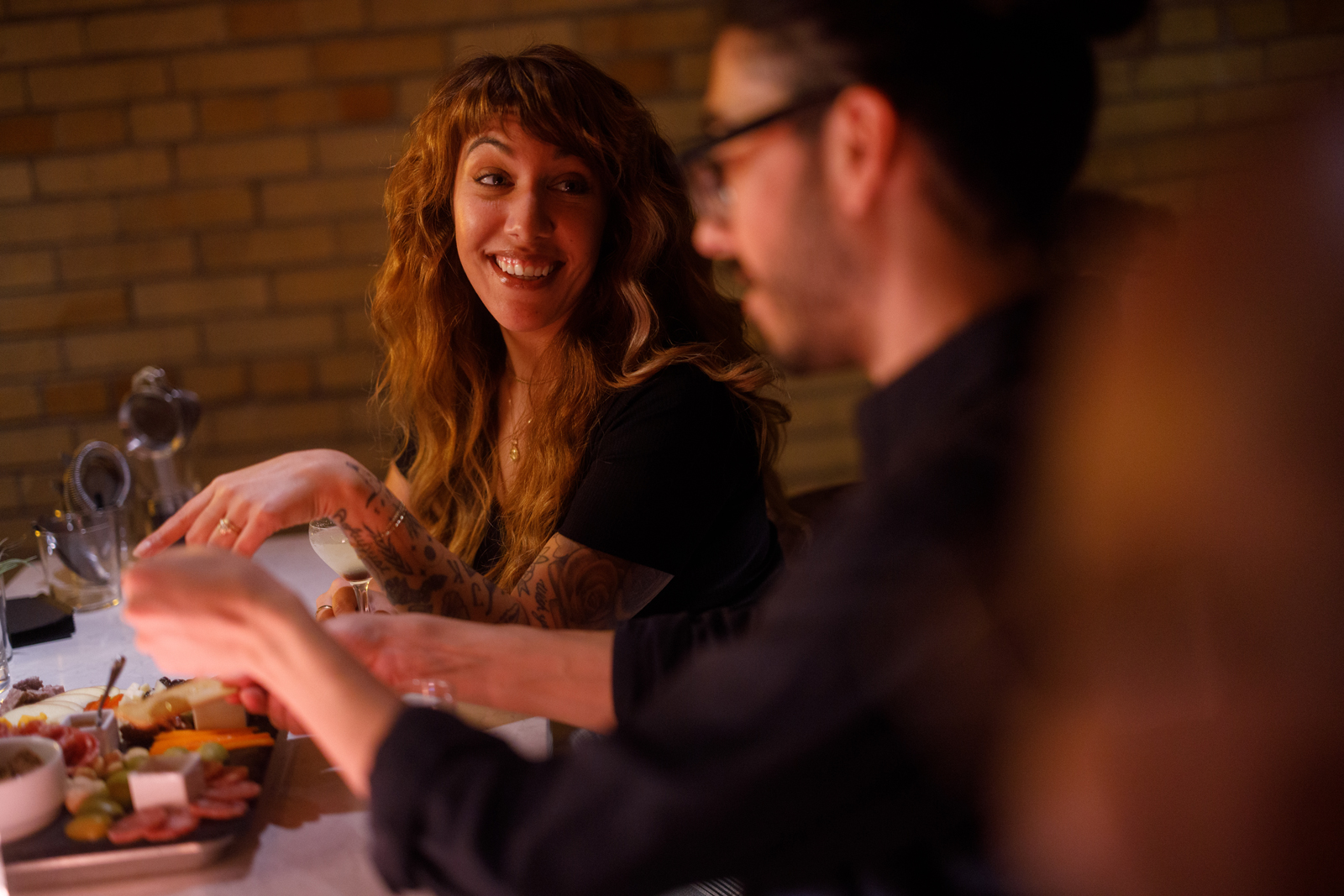 Two people sitting at a bar with food